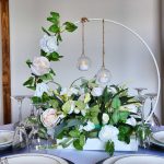 Hoop table centrepieces with green & white foliage and glass baubles with LED candles