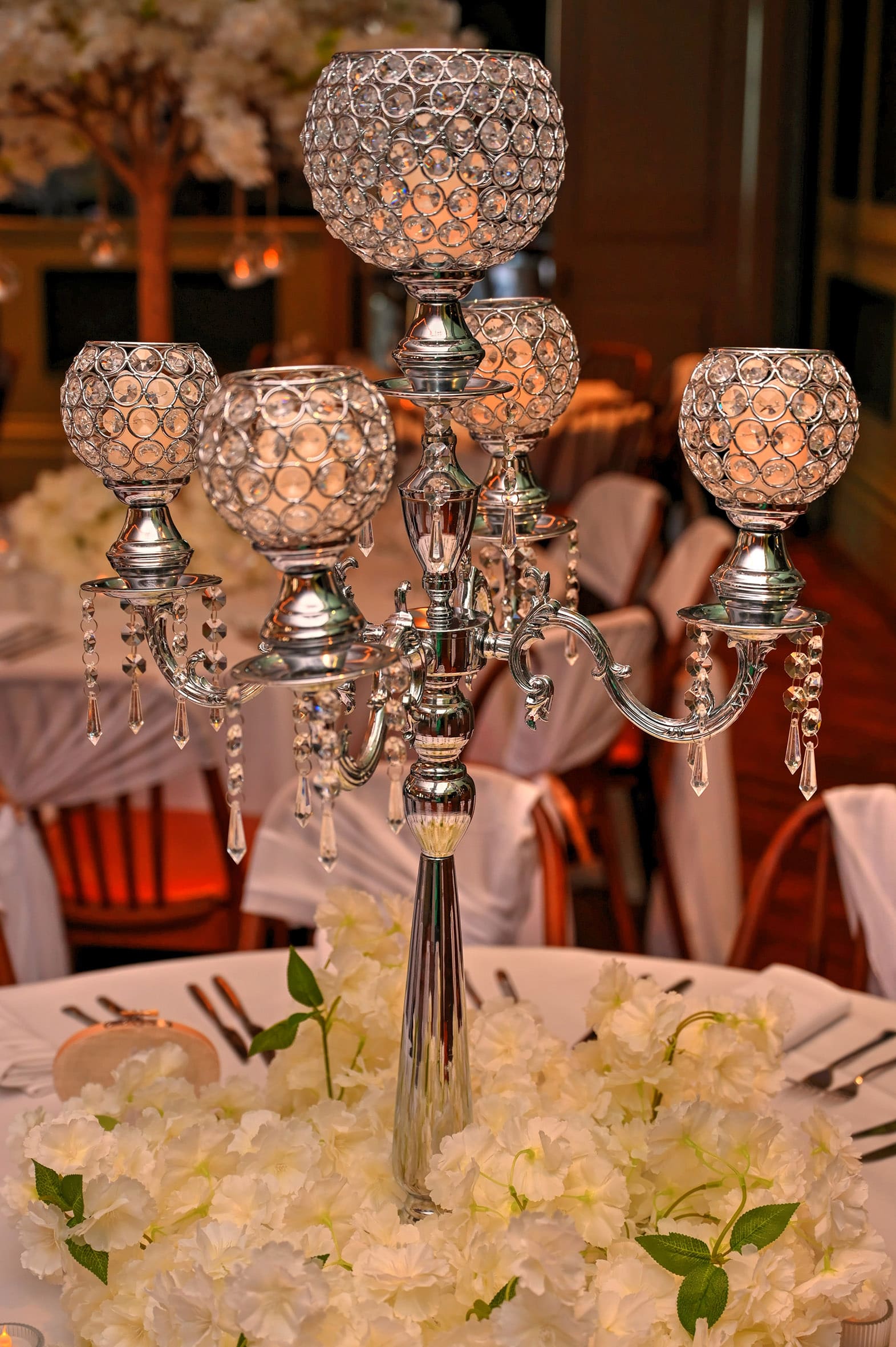 Elegant 5-arm silver goblet candelabra with teardrop crystals on a white floral wreath