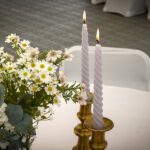 Wild flowers in bud vases with lavender taper candles in gold antique holders as table centrepiece