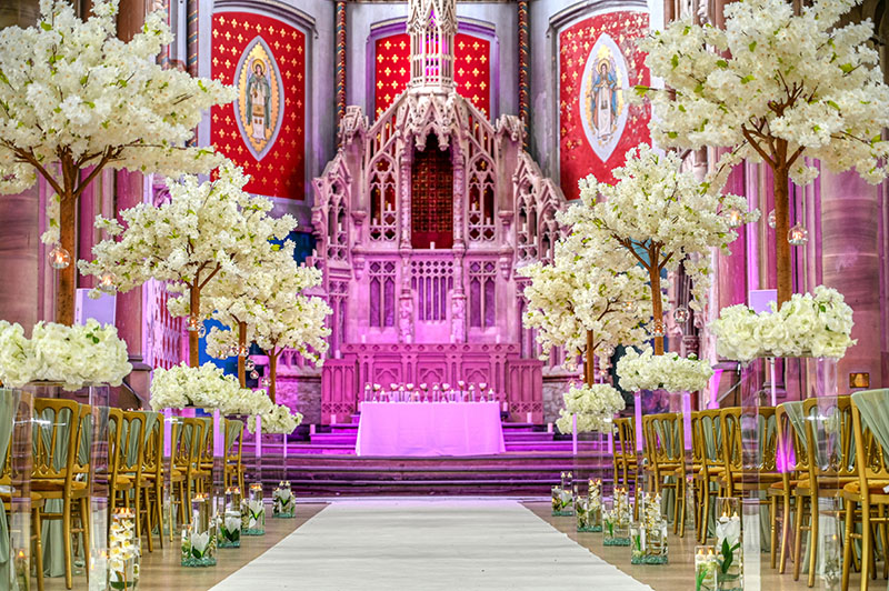 Canopy of blossom trees lining the aisle for a wedding ceremony