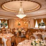 Ceiling chandelier in the Goulburn Suite at Manchester Hall with wedding breakfast setup featuring floral ball and floral wreaths centrepieces
